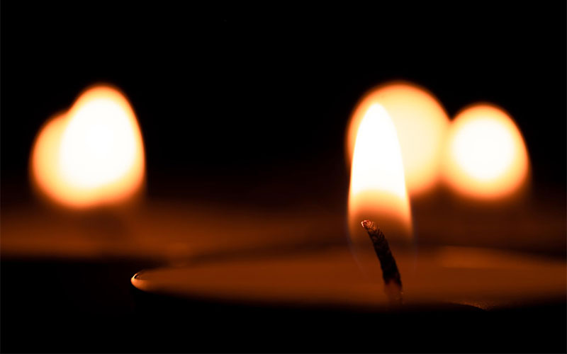 Lit candles that are flickering against a dark background.